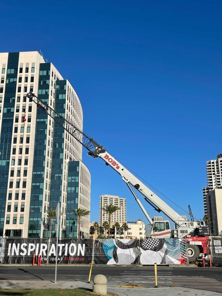 Truck-mounted boom lift extended beside a high-rise building