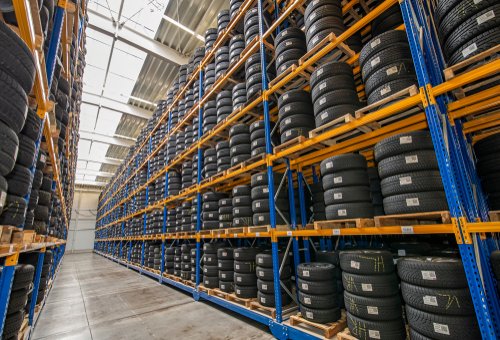 Warehouse aisle lined with tall racks of tires