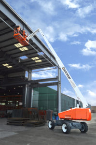 A forklift in front of a large building.