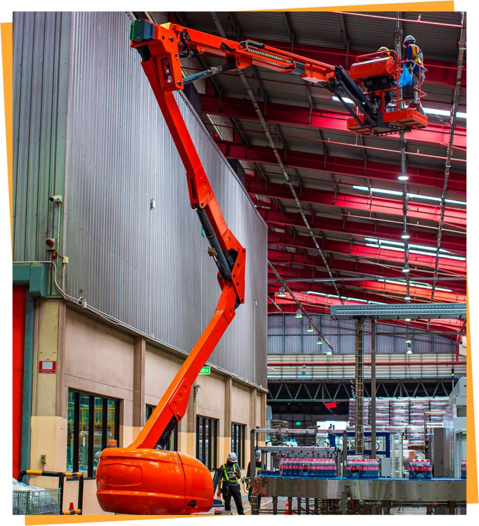 a large orange crane in a large building.