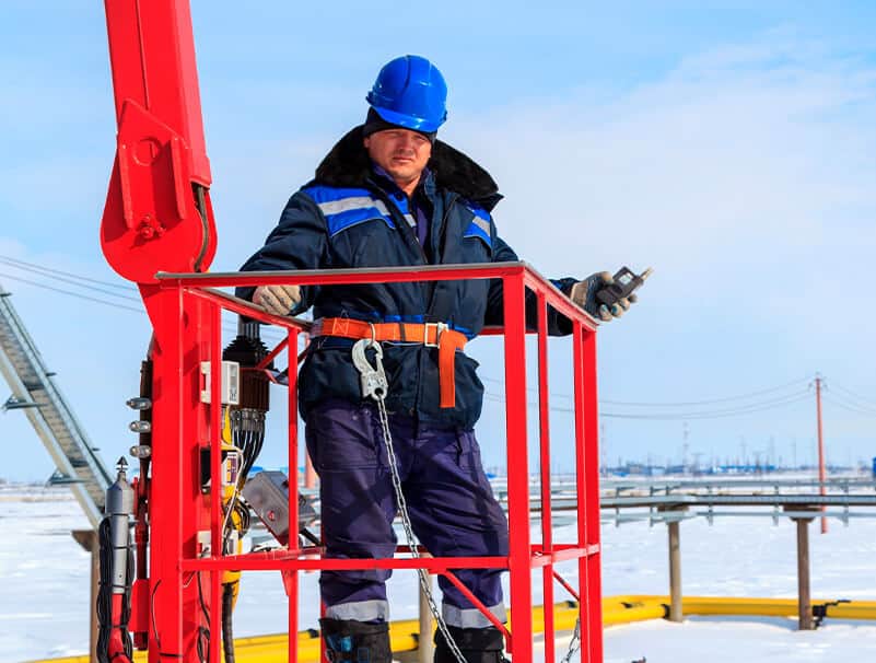 a man in a hard hat standing on a red structure.