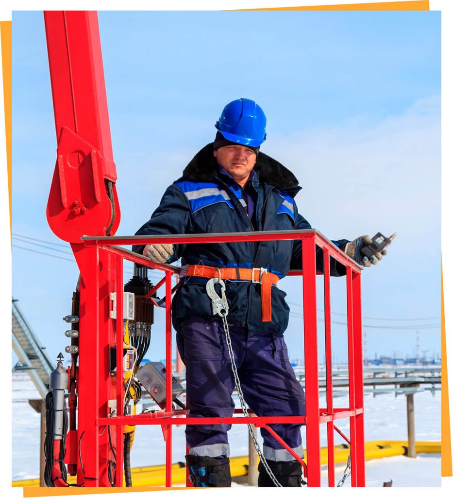 a man in a hard hat standing on a red structure.