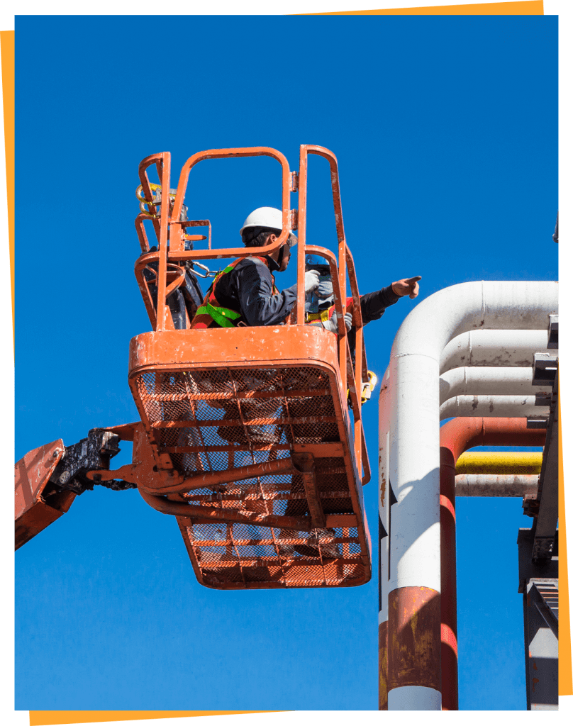 a man on a lift working on a pipe.