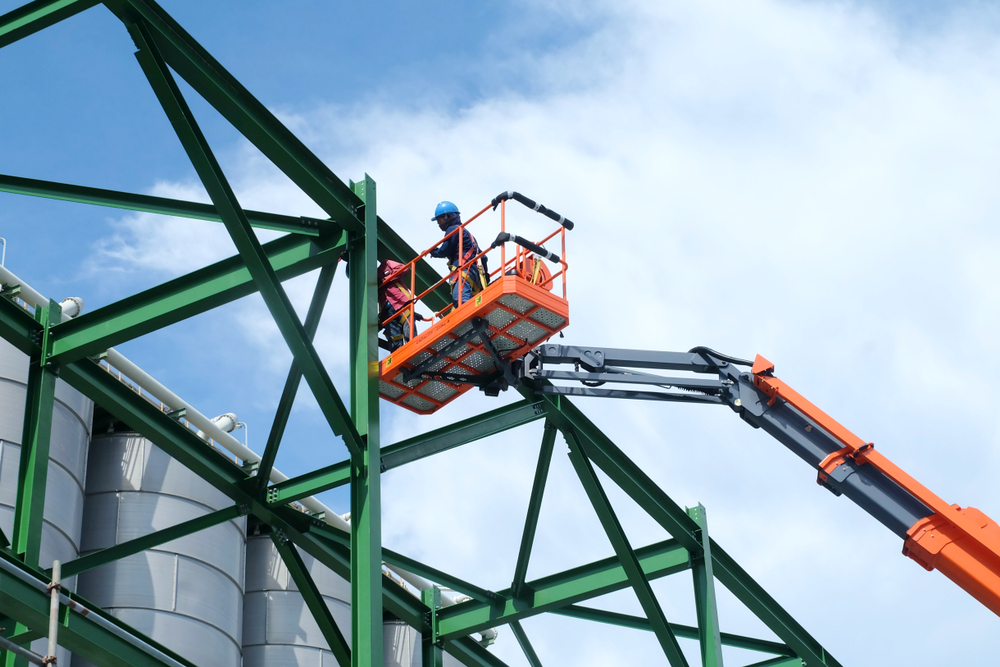 a man on a boom lift working on a structure.